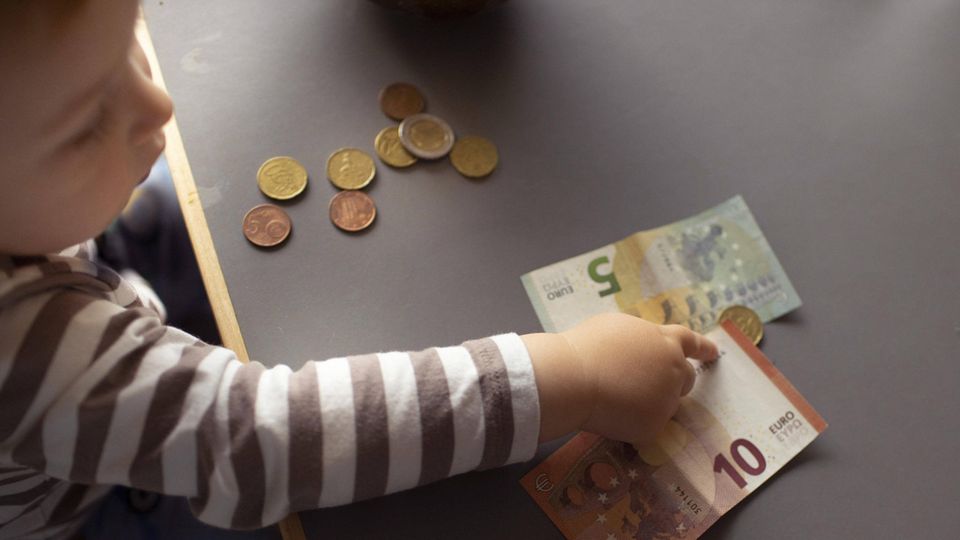 Ein Kind zeigt auf Geldscheine