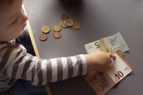 Ein Kind zeigt auf Geldscheine