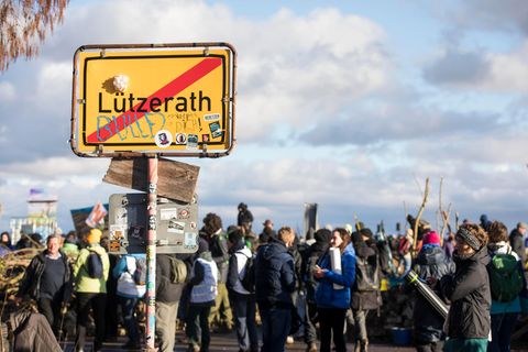Aktivisten vor dem Ortsausgangsschild von Lützerath