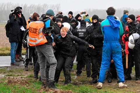 Bei Lützerath trifft ein Trupp maskierter Polizisten auf Demonstrantinnen und Demonstranten
