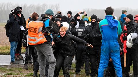 Bei Lützerath trifft ein Trupp maskierter Polizisten auf Demonstrantinnen und Demonstranten