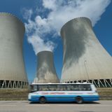 Ein Bus fährt vor den Kühltürmen des Atomkraftwerks Temelin entlang