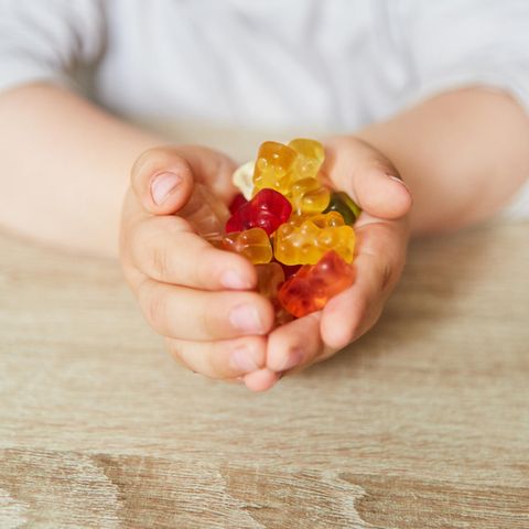 Ein Kind hält Gummibärchen in den Händen
