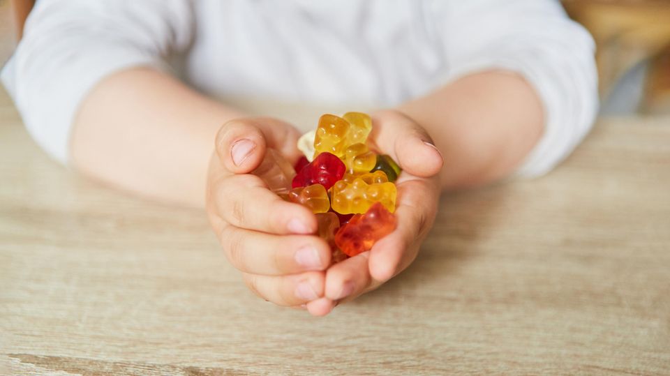 Ein Kind hält Gummibärchen in den Händen