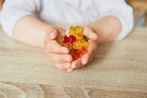 Ein Kind hält Gummibärchen in den Händen