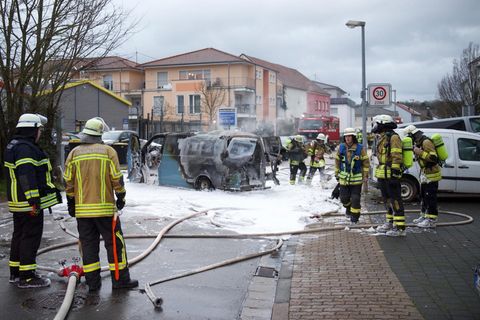 Einsatzkräfte stehen um den gelöschten Geldtransporter in Saarlouis