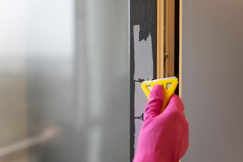 Eine Person entfernt Reste eines Aufklebers