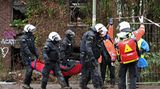 Polizei und Rettungskräfte transportieren ein Person vom Gelände in Lützerath