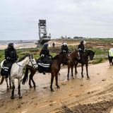 Berittene Polizisten stehen am Rande des Tagebaus