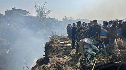 Retter und Schaulustige versammeln sich an der Absturzstelle des Flugzeugs in Pokhara