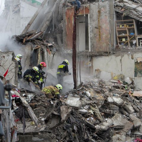 Ukraine, Dnipro: Rettungskräfte beseitigen die Trümmer und suchen nach Menschen in dem Wohnblock