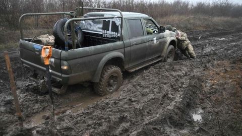 Ukraine: Soldaten versuchen ein Auto aus dem Schlamm zu schieben