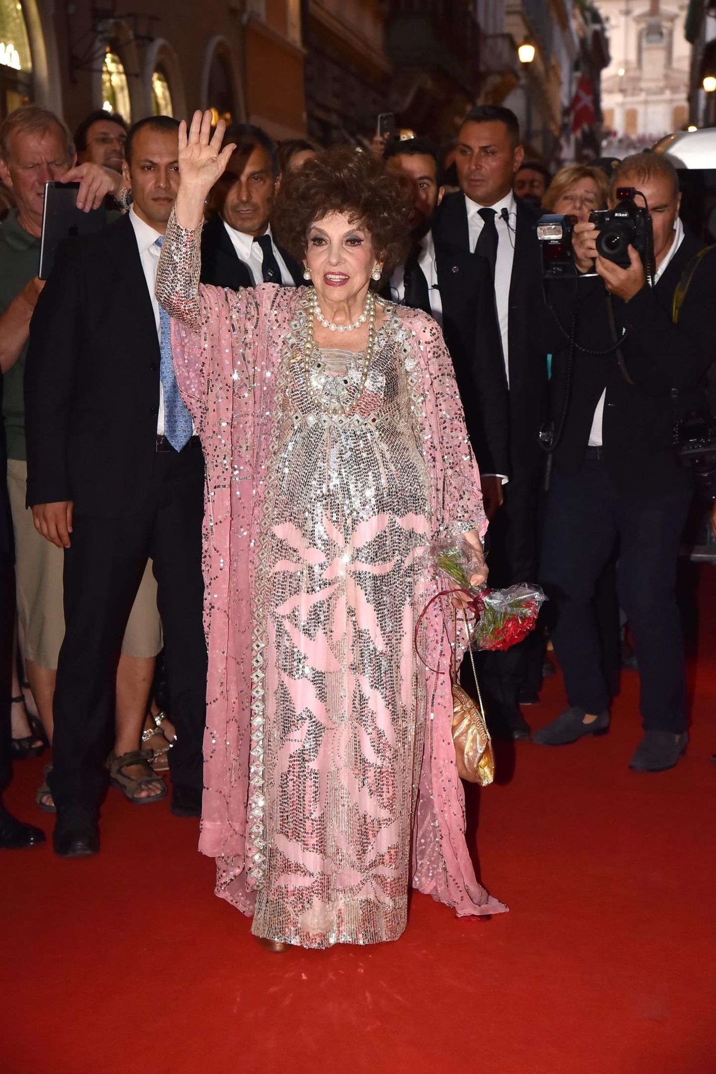 Gina Lollobrigida hebt auf dem Roten Teppich die Hand zum Gruß für die Kameras