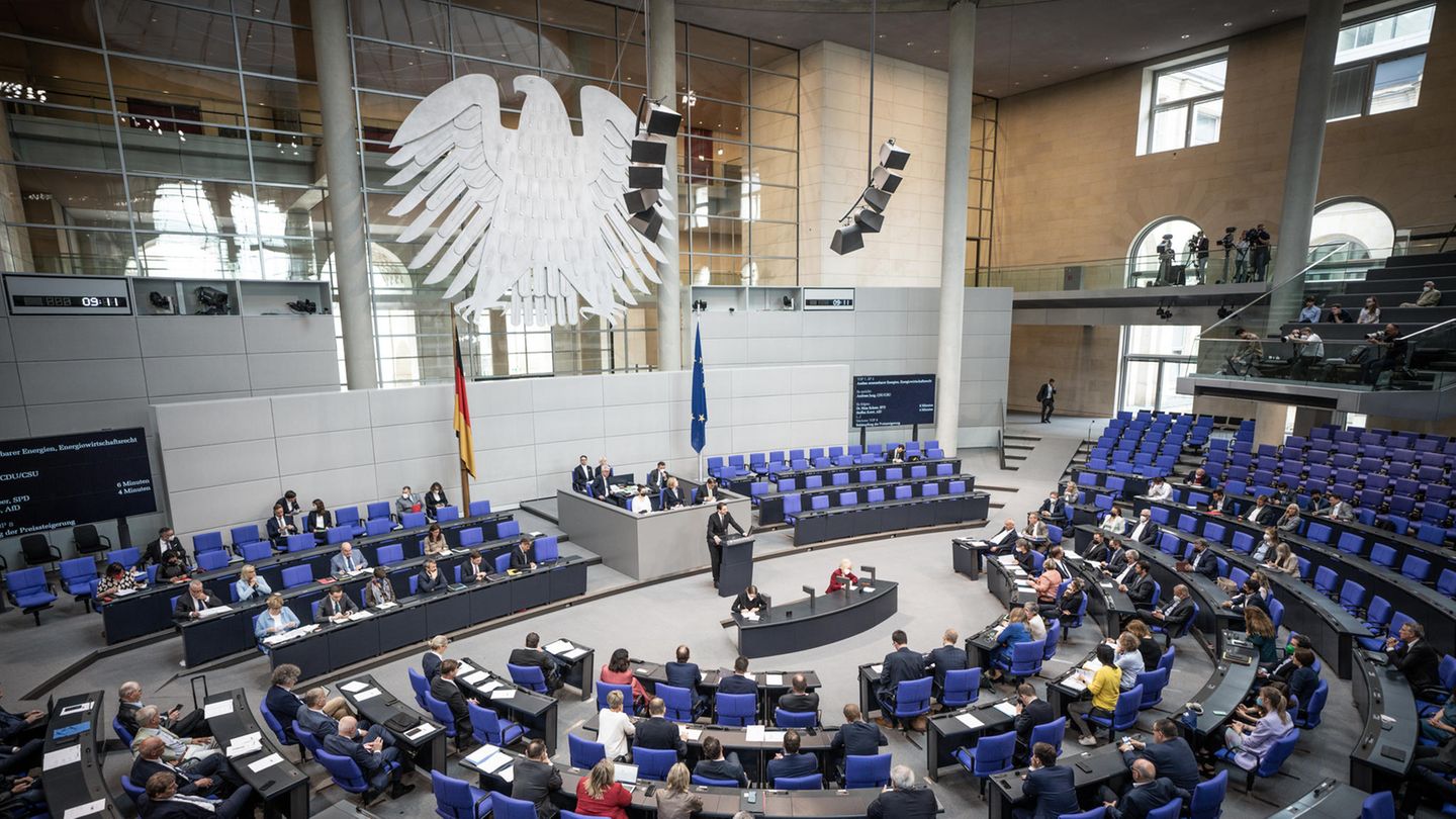 Von der Empore des Bundestags in Berlin schaut man ins Plenum, in dem die Abgeordneten unter einem silbernen Bundesadler sitzen