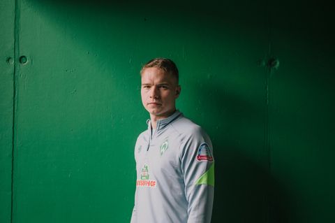 Werder-Profi Niklas Schmidt vor einer Wand im Weserstadion