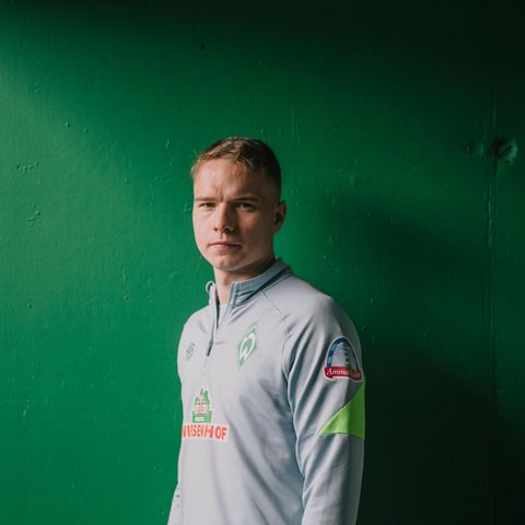 Werder-Profi Niklas Schmidt vor einer Wand im Weserstadion