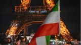 Paris, Frankreich. Der Eiffelturm leuchtet in der Nacht mit dem Slogan "Femme, vie, liberté" ("Frau, Leben, Freiheit") zur Unterstützung der Proteste im Iran, während im Vordergrund eine iranische Fahne weht. Der Tod der iranischen Kurdin Jina Mahsa Amini Mitte September vergangenes Jahr hatte landesweite Proteste im Iran ausgelöst. Die junge Frau war in Polizeigewahrsam gestorben, nachdem sie von der sogenannten Sittenpolizei wegen Verstoßes gegen die islamischen Kleidungsvorschriften festgenommen worden war.