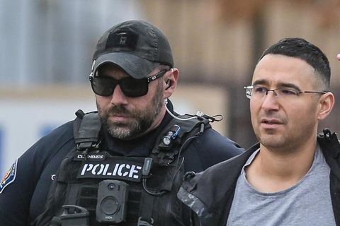 Der Republikaner Solomon Peña geht mit den Armen auf dem Rücken zwischen zwei US-Polizisten mit Schutzwesten und Sonnenbrillen