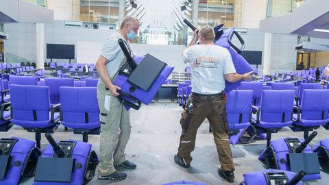 Handwerker montieren blaue Sitze im deutschen Bundestag