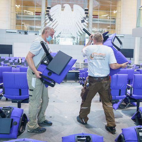 Handwerker montieren blaue Sitze im deutschen Bundestag
