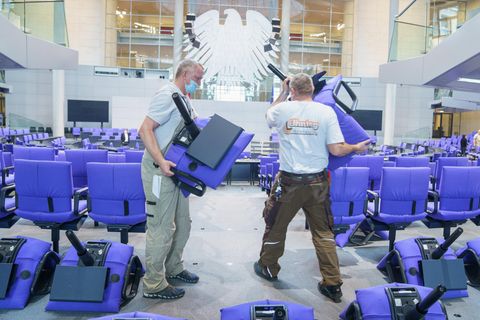 Handwerker montieren blaue Sitze im deutschen Bundestag