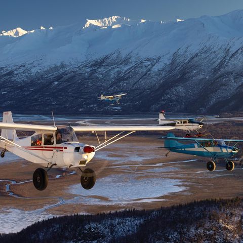 Vier Maschinen fliegen in Formation den Knik River entlang