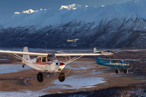 Vier Maschinen fliegen in Formation den Knik River entlang