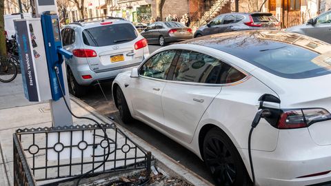 Ein Elektroauto lädt an einer Ladestation am Straßenrand