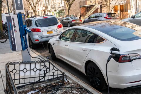 Ein Elektroauto lädt an einer Ladestation am Straßenrand