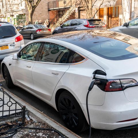 Ein Elektroauto lädt an einer Ladestation am Straßenrand