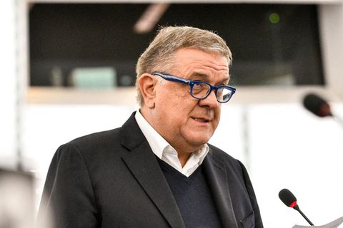 Pier Antonio Panzeri, ein älterer weißer Mann mit blauer Brille steht im Jackett vor einem Mikro und hält Zettel in der Hand