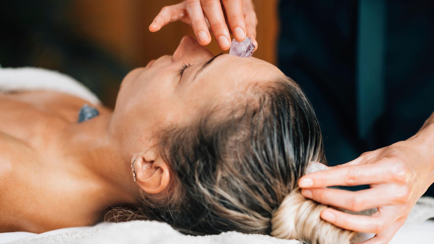 Eine Frau erhält eine Behandlung durch Kristalltherapie Eine Frau erhält eine Behandlung durch Kristalltherapie