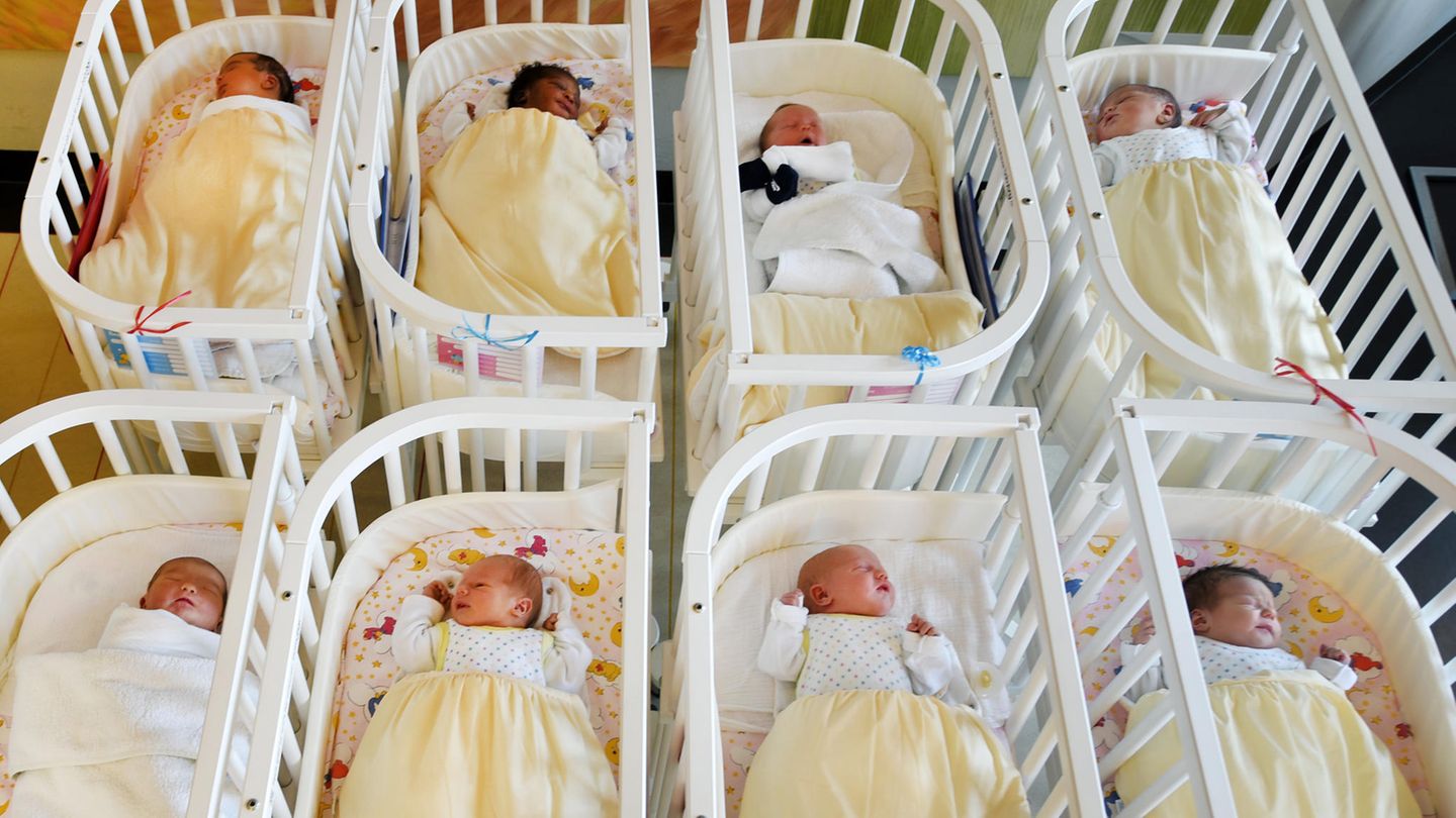 Mehrere Babys liegen in ihren Krankenhausbetten nebeneinander