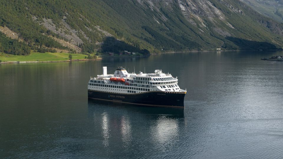 A ship sails through a fjord in Norway