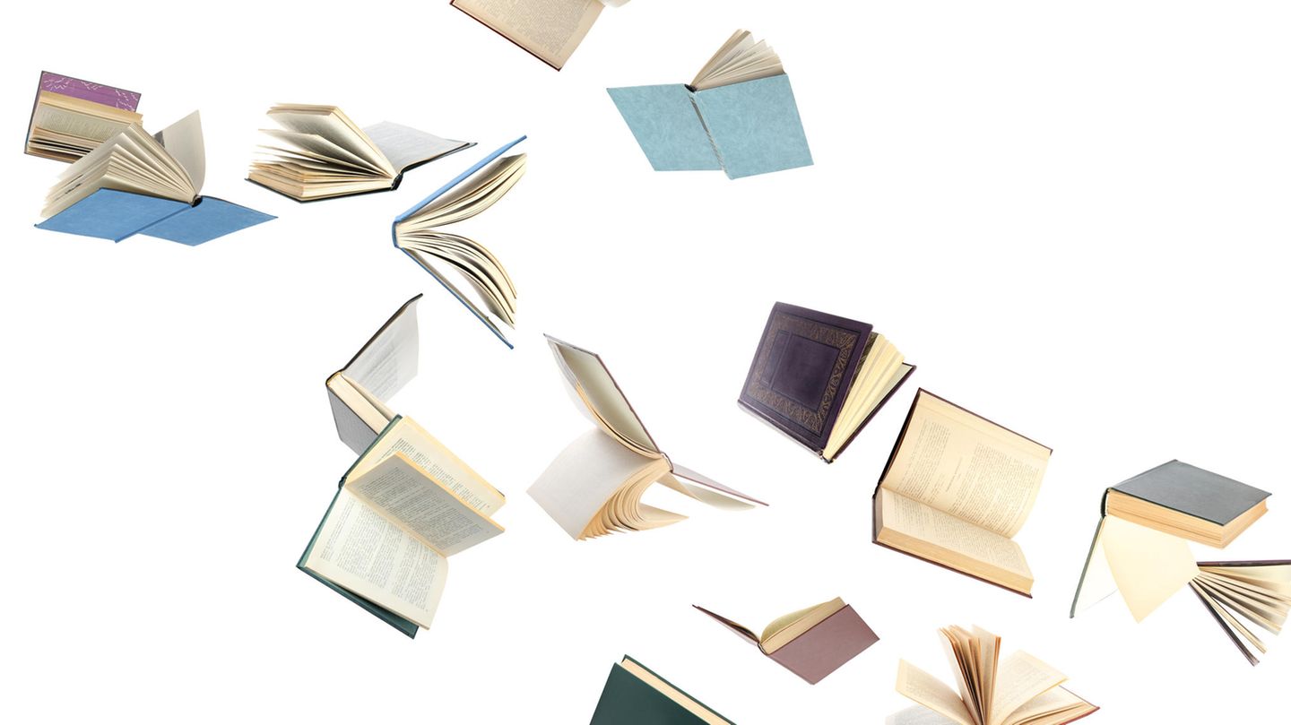 Bücher fallen vor weißem Hintergrund