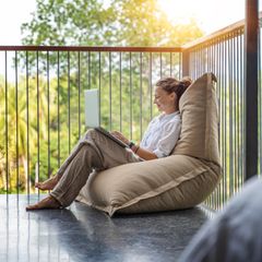 Eine Frau sitzt auf einem Outdoor-Sitzsack.