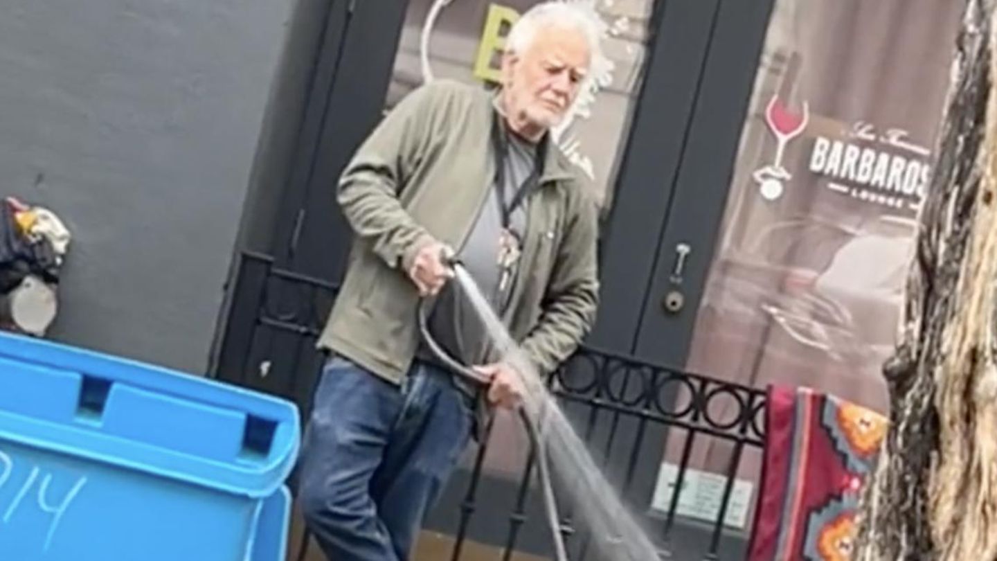 Ein Galerist besprüht eine obdachlose Frau in San Francisco