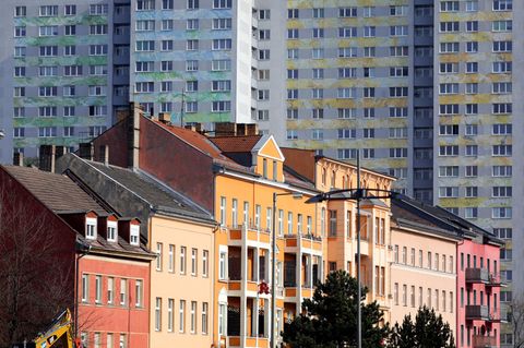 Reihenhäuser stehen vor einem Plattenbau in Berlin
