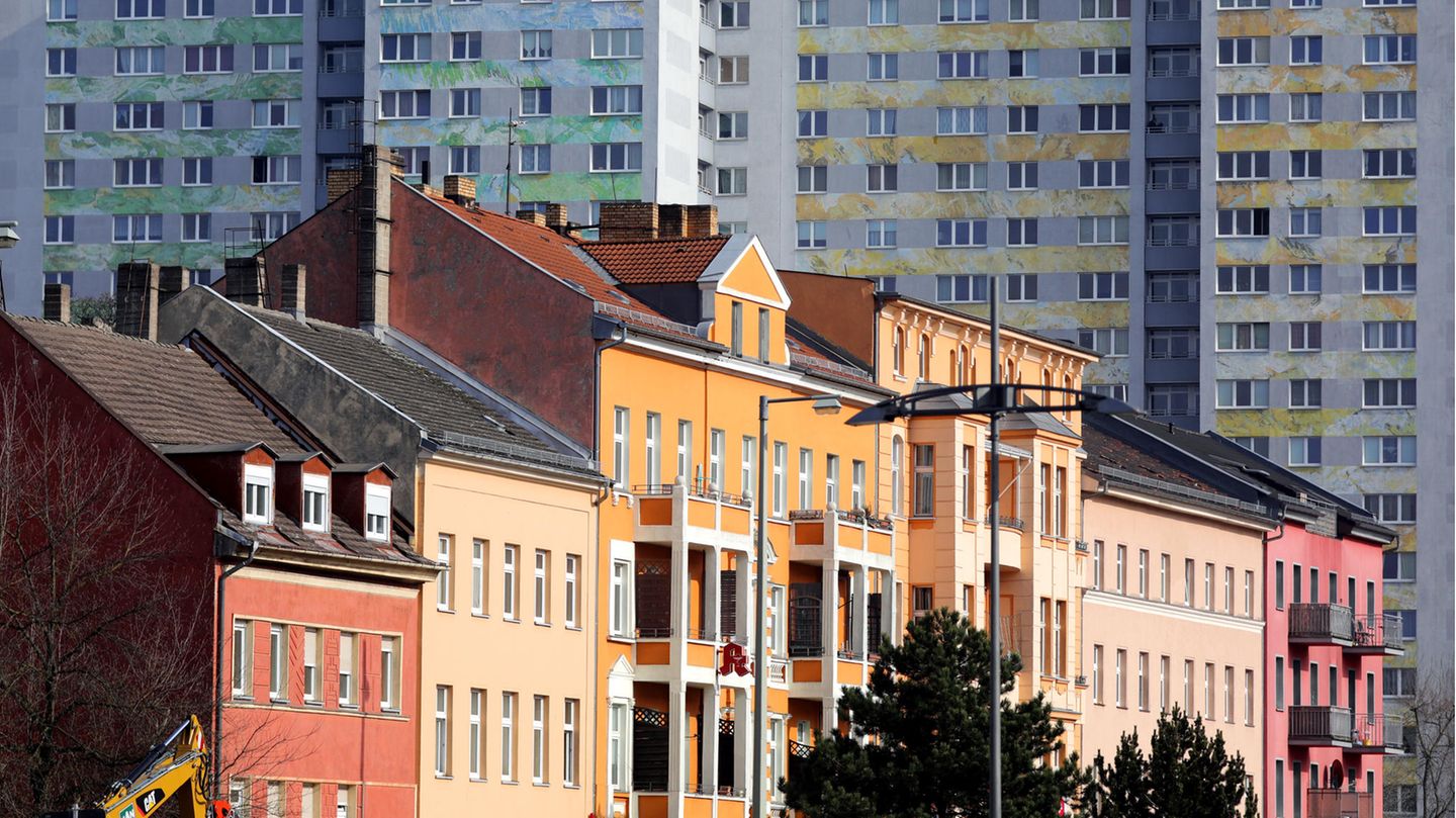 Reihenhäuser stehen vor einem Plattenbau in Berlin