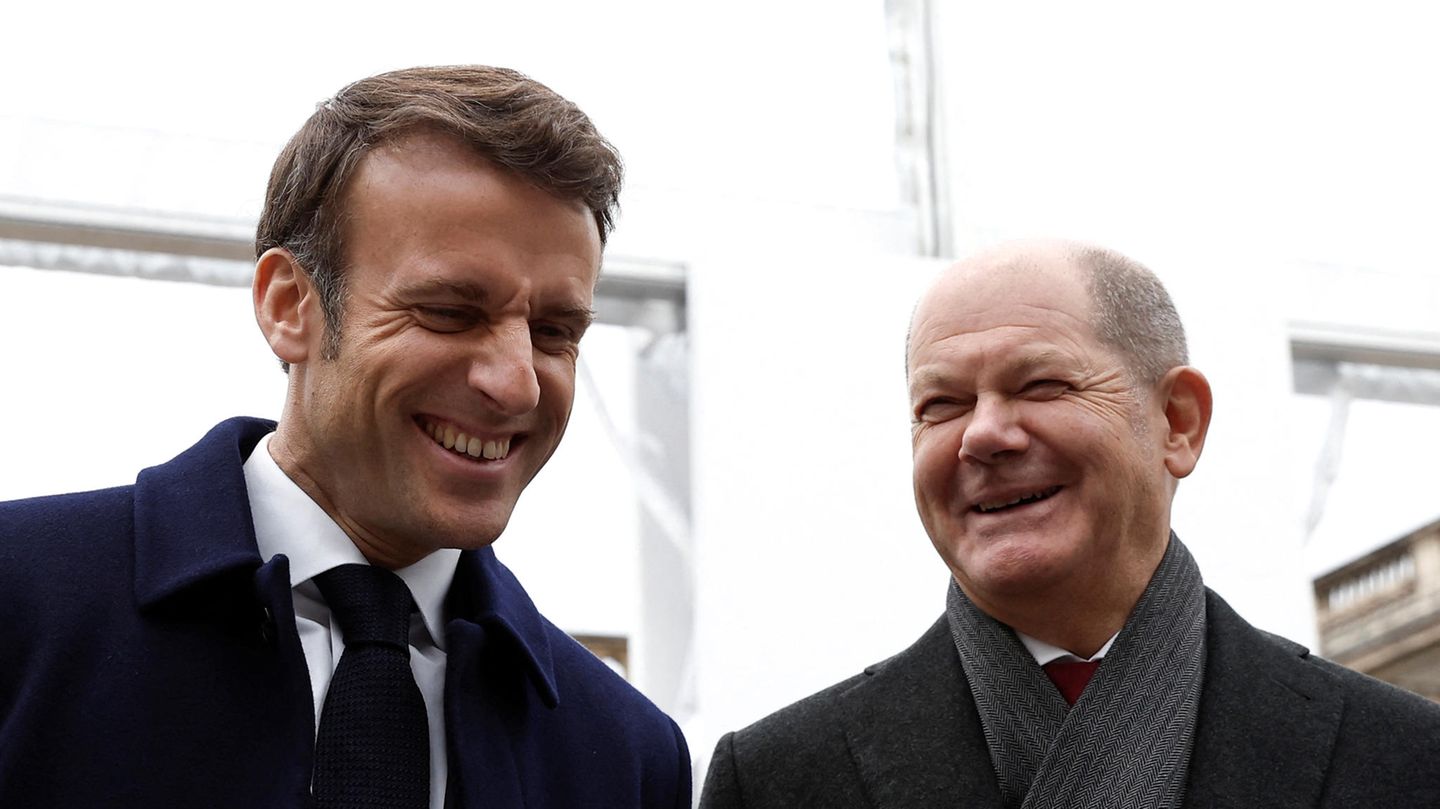 Bundeskanzler Olaf Scholz (SPD, r) und Emmanuel Macron, Präsident von Frankreich, lachen