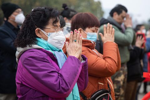 In Wuhan beten zwei Frauen, während sie OP-Masken gegen das Coronavirus tragen