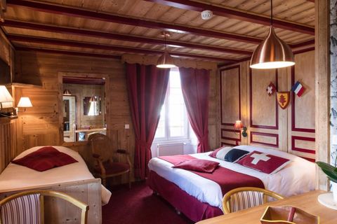 Hotelzimmer und Bett mit Kissen der Landesflaggen der Schweiz und Frankreichs