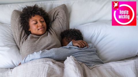 Mutter und Sohn schlafen auf einem Bett