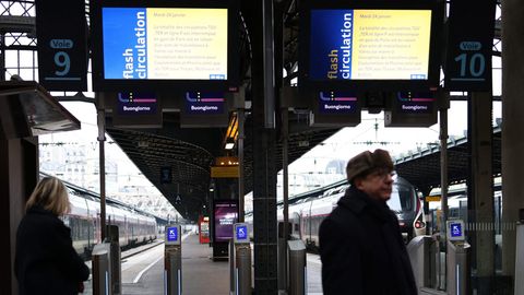 Menschen stehen vor Anzeigetafeln am Pariser Gare de l'Est