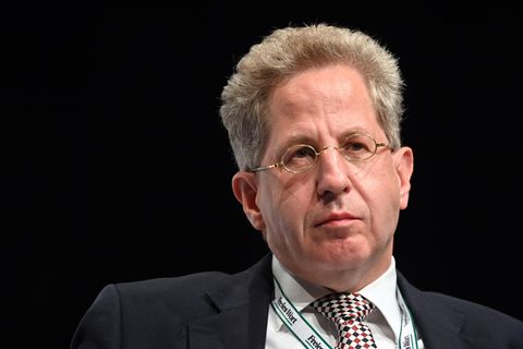 Hans-Georg Maaßen, ein weißer Mann mit schwarz-grauem Bürstenschnitt und silberner Nickelbrille, sitzt im Anzug auf einem Podium