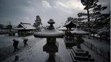 Nagaon, Japan. Friedlich sieht die Welt unter der weißen Schneedecke aus. Zwei Besucher nutzen die frühen Morgenstunden, um die Ruhe beim Zenkoji Temple zu genießen.
