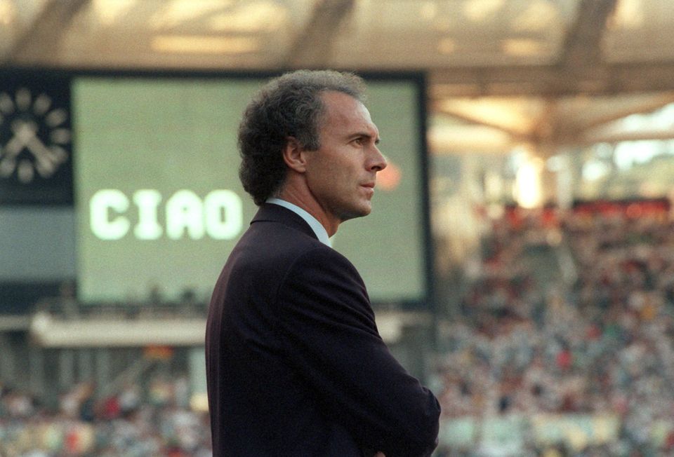 Franz Beckenbauer schaut mit ernstem Gesicht auf das Spielfeld des Olympiastadions
