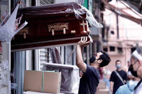 Ein Mann in Hongkong transportiert einen Sarg.