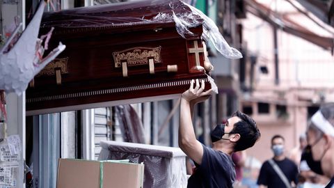 Ein Mann in Hongkong transportiert einen Sarg.