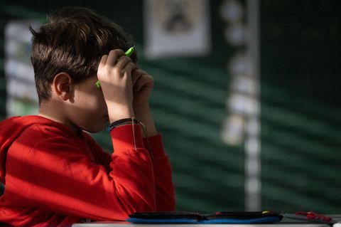 Ein Schüler hält beide Hände an den Kopf